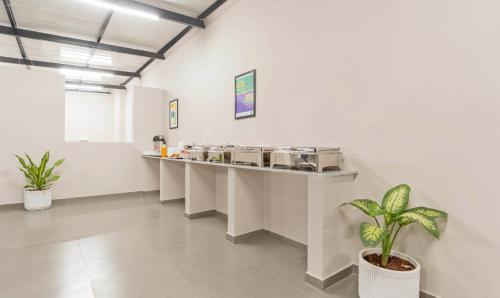 een wachtkamer met een balie en een plant bij Treebo Global Orchid in Mysore