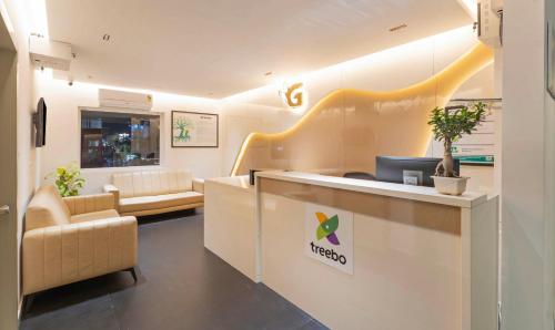 een lobby met een wachtkamer met een receptiebalie bij Treebo Global Orchid in Mysore
