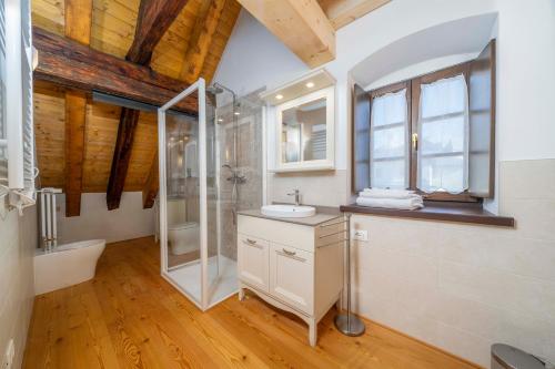 un bagno con doccia, lavandino e WC di GuestHost - Antica Ferrovia Apartments Tarvisio a Tarvisio