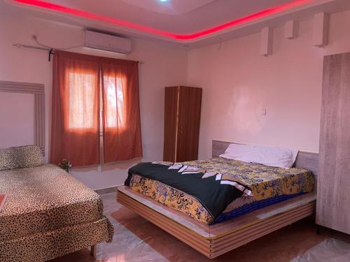 um quarto com uma cama com uma luz vermelha em Mdf Saloum em Poundiougne