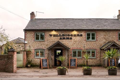 an old brick building with a sign that reads winery aid at The Welldiggers Arms in Petworth