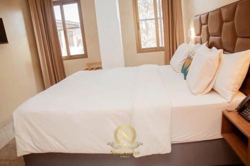 Postel nebo postele na pokoji v ubytování Nyota Lodge Hôtel