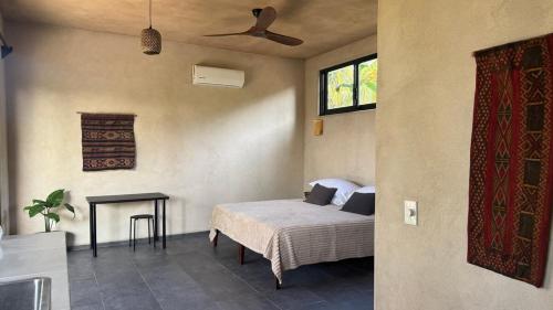 ein Schlafzimmer mit Bett, Tisch und Deckenventilator in der Unterkunft Quiet Oceanside Casita Private Kitchen & Bath in Troncones
