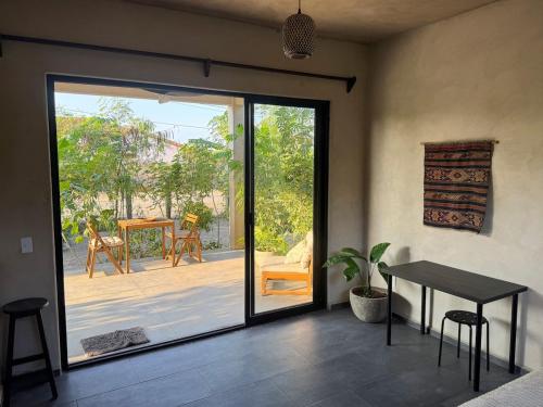 ein Raum mit einer Glasschiebetür mit einem Tisch und einer Terrasse in der Unterkunft Quiet Oceanside Casita Private Kitchen & Bath in Troncones