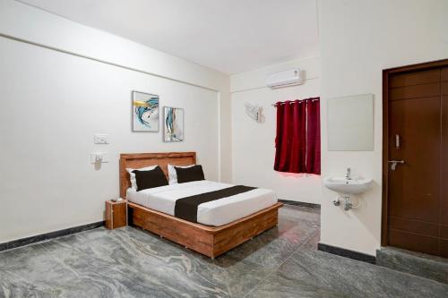 Hotel O Jodi Sri Muneshwara Swamy Temple في Jālahalli: غرفة نوم بسرير ومغسلة