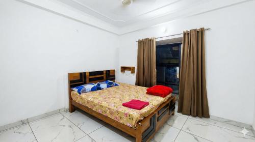 a bedroom with a bed with two red pillows on it at SAIS LINE Residency in Kozhikode