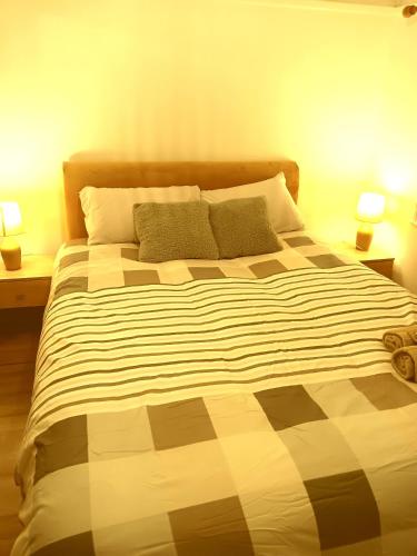 een groot bed in een slaapkamer met twee lampen bij High class accommodation in Bury