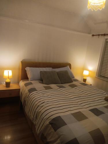 a bedroom with a large bed with two lamps at High class accommodation in Wythenshawe
