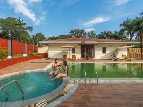 um grupo de pessoas sentadas em uma piscina em The Hosteller Bam Coorg em Madikeri