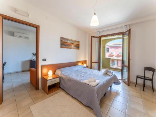 a bedroom with a bed and a table and a chair at Premium apartment in Villasimius in Villasimius