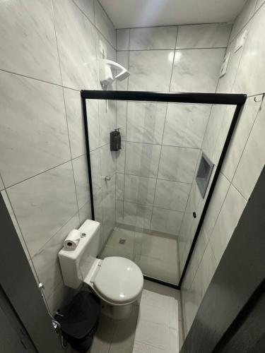 a small bathroom with a toilet and a shower at Sol da pipa - suítes in Pipa