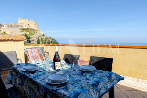 a table with glasses and a bottle of wine on a balcony at Castello 4 in Isola del Giglio