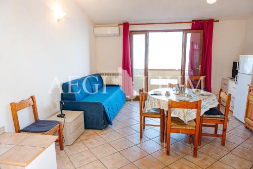 a living room with a table and a blue couch at Castello 4 in Isola del Giglio