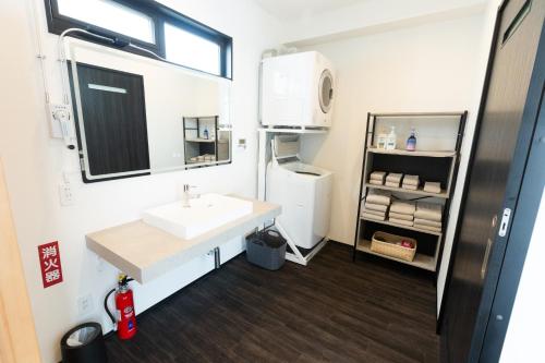 bagno con lavandino e frigorifero di 2025年12月オープンのリベルテ瀬底サウナプールで整う1棟貸 a Sesoko