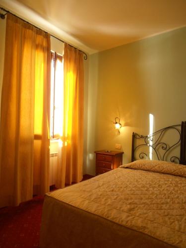 a bedroom with a bed and a window at Hotel Garnì Bartabel in Gargnano