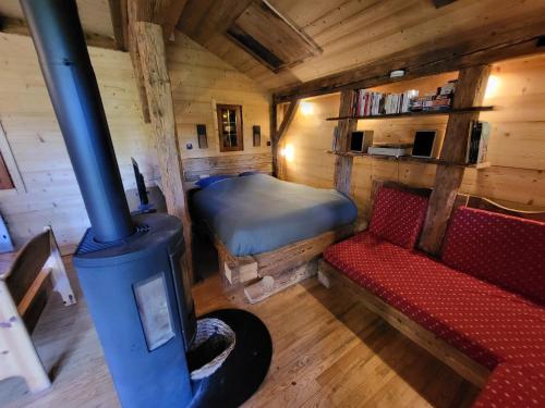 een kamer met een kachel, een bank en een bed bij Chalet Chamois & Spa in Lullin