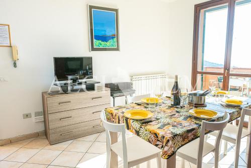 a dining room with a table with chairs and a television at Castello 9 in Isola del Giglio