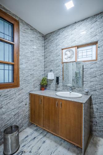 a bathroom with a sink and a window at Anji Retreat in Dharampur