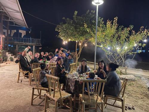 a group of people sitting at a table at night at Nùng An homestay-Nùng ethnic group in Bà Dương
