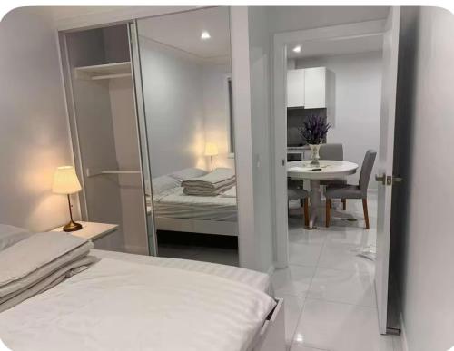 a bedroom with a bed and a table and a mirror at Modern 1 or 2-Bedroom Granny Flat Near Parramatta CBD in Sydney