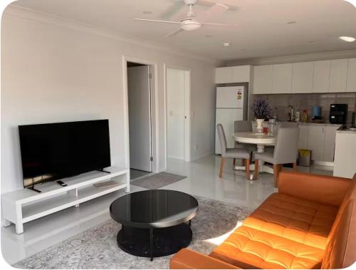 a living room with a couch and a tv and a table at Modern 1 or 2-Bedroom Granny Flat Near Parramatta CBD in Sydney