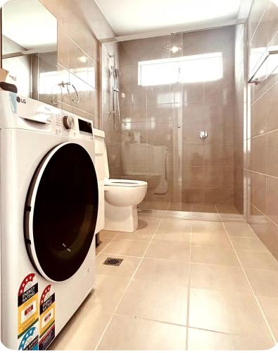 a washing machine in a bathroom with a toilet at Modern 1 or 2-Bedroom Granny Flat Near Parramatta CBD in Sydney