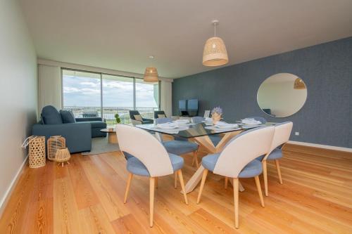 a dining room and living room with a table and chairs at Bayline X in Armação de Pêra