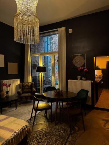 een woonkamer met een tafel en een kroonluchter bij Sān home’s in Antwerpen