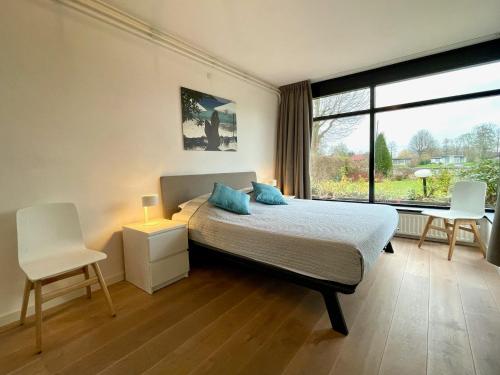 een slaapkamer met een bed, een bureau en een raam bij OPt7 in Arnemuiden