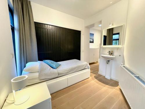 een kleine slaapkamer met een bed en een wastafel bij OPt7 in Arnemuiden