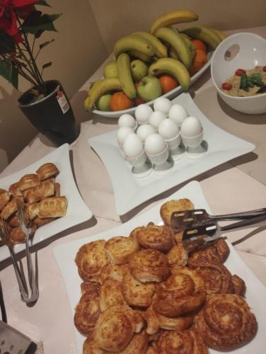 un tavolo ricoperto di piatti di prodotti da forno e frutta di Classic Inn Hotel by Radacini a Braşov