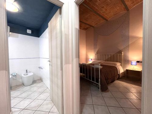 ein Schlafzimmer mit Bett und ein Badezimmer mit Waschbecken in der Unterkunft Il Nido delle Logge in Siena