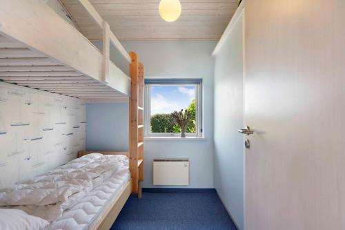 Un dormitorio con una litera y una ventana. en Lovely Holiday Home Near Beach And Nature, en Karrebæksminde