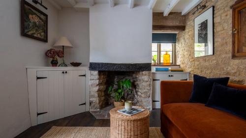 ein Wohnzimmer mit Sofa und Kamin in der Unterkunft Armada Cottage in Charlbury