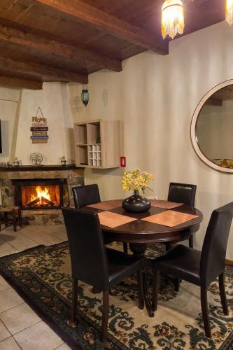 een eetkamer met een tafel en stoelen en een open haard bij Horizon Nest Parnassos Villa Chalet! in Eptalofos