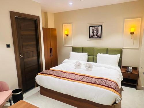 a bedroom with a large bed with white sheets at Hotel Supreme Inn in Varanasi