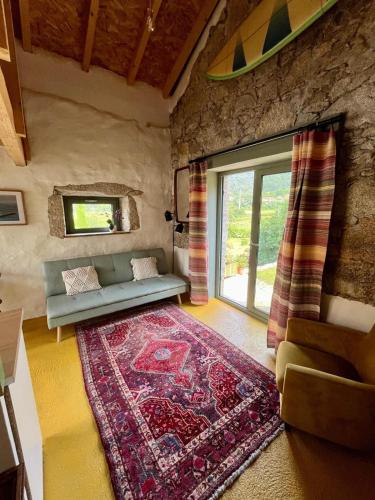 ein Wohnzimmer mit Sofa und Teppich in der Unterkunft Mar Dentro in Âncora