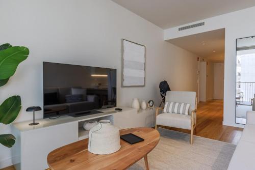 a living room with a large television and a table at Bayline Solaris 4 in Armação de Pêra