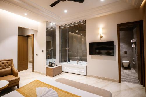 卢迪亚纳Crown Palazzo的一间带浴缸和淋浴的浴室以及一台电视。