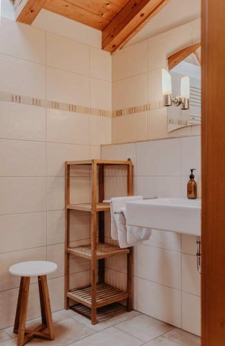 a bathroom with a sink and a stool at Gästehaus Wechs - inklusive Hindelang PLUS in Bad Hindelang