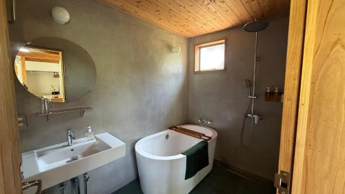 un bagno con lavandino, WC e vasca di 月みるいえ ad Akaogi