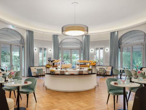Un restaurante con mesas y sillas y un buffet. en The 1932 Hotel & Spa Cap d'Antibes - MGallery Collection, en Juan-les-Pins