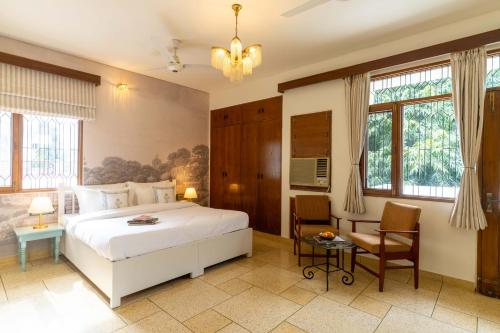 een slaapkamer met een wit bed en een tafel en stoelen bij Jobner Haus Jaipur in Jaipur