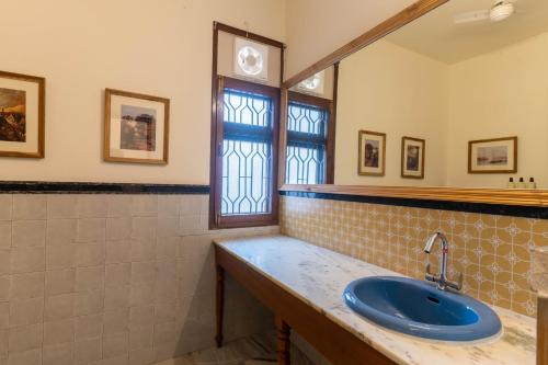 een badkamer met een blauwe wastafel en een spiegel bij Jobner Haus Jaipur in Jaipur
