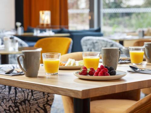 uma mesa com um prato de fruta e sumo de laranja em Le Saint Gervais Hotel & Spa Handwritten Collection em Saint-Gervais-les-Bains