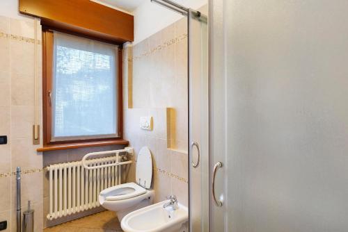 ein Badezimmer mit Toilette und Waschbecken und einem Fenster in der Unterkunft Residence Le Ante - Cadore in Santo Stefano di Cadore