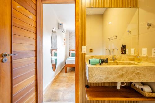 a bathroom with a sink and a large mirror at Pousada Preamar in Prea
