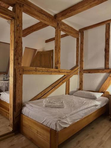 a large bed in a room with wooden beams at Karczma Bełty in Glinno