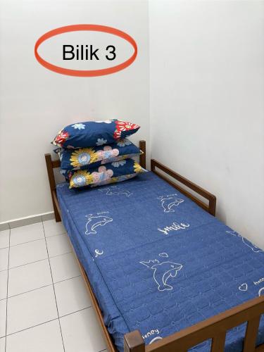 a bedroom with a bed with blue sheets and pillows at HOMESTAY CIKGU NORa near UTHM KPTM KKTM IPG Moslim onli in Kampong Seri Gading