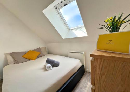 een kleine slaapkamer met een bed en een raam bij Appartement Centre Saint-Omer, Parking privé gratuit in Saint-Omer